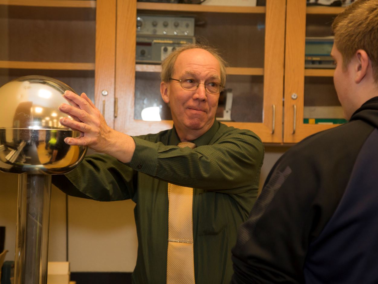 Instructor demonstrating a Van de Graaff generator.