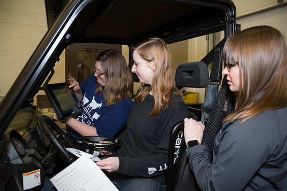 girls in a tractor cab